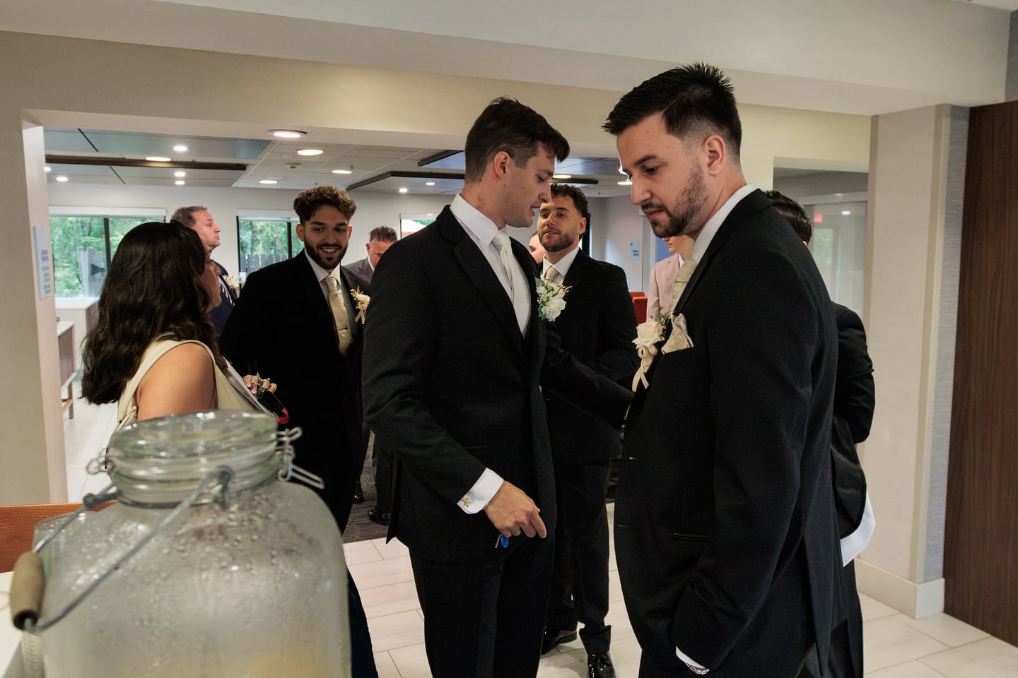 Men in suits gather and talk around a table before the ceremony.