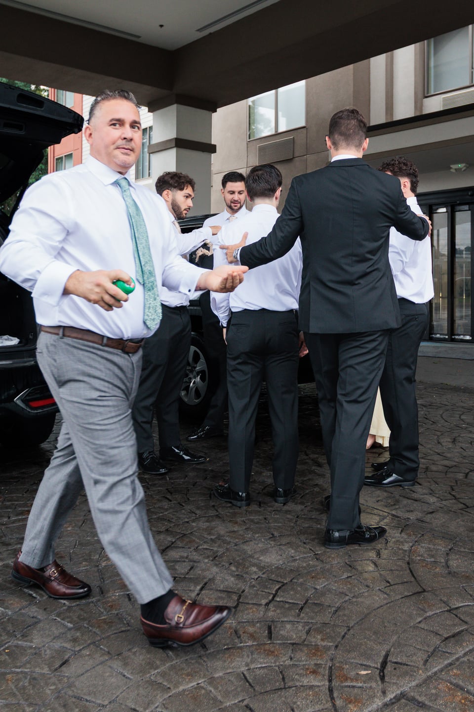Wedding guests talk and laugh outside the hotel before the ceremony.