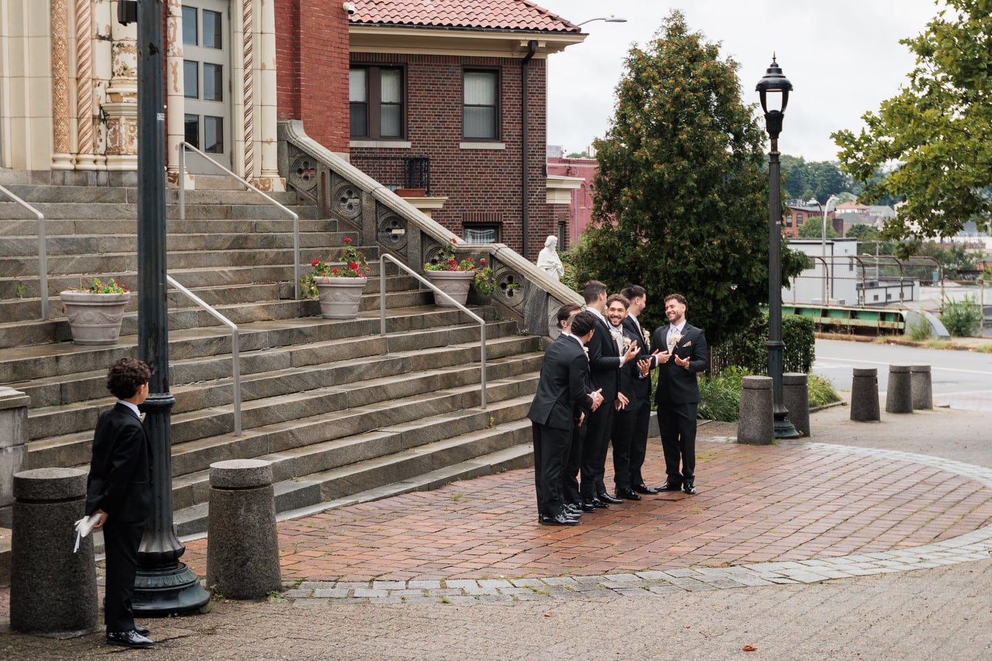 Members of the wedding party gather near the church steps before the ceremony.