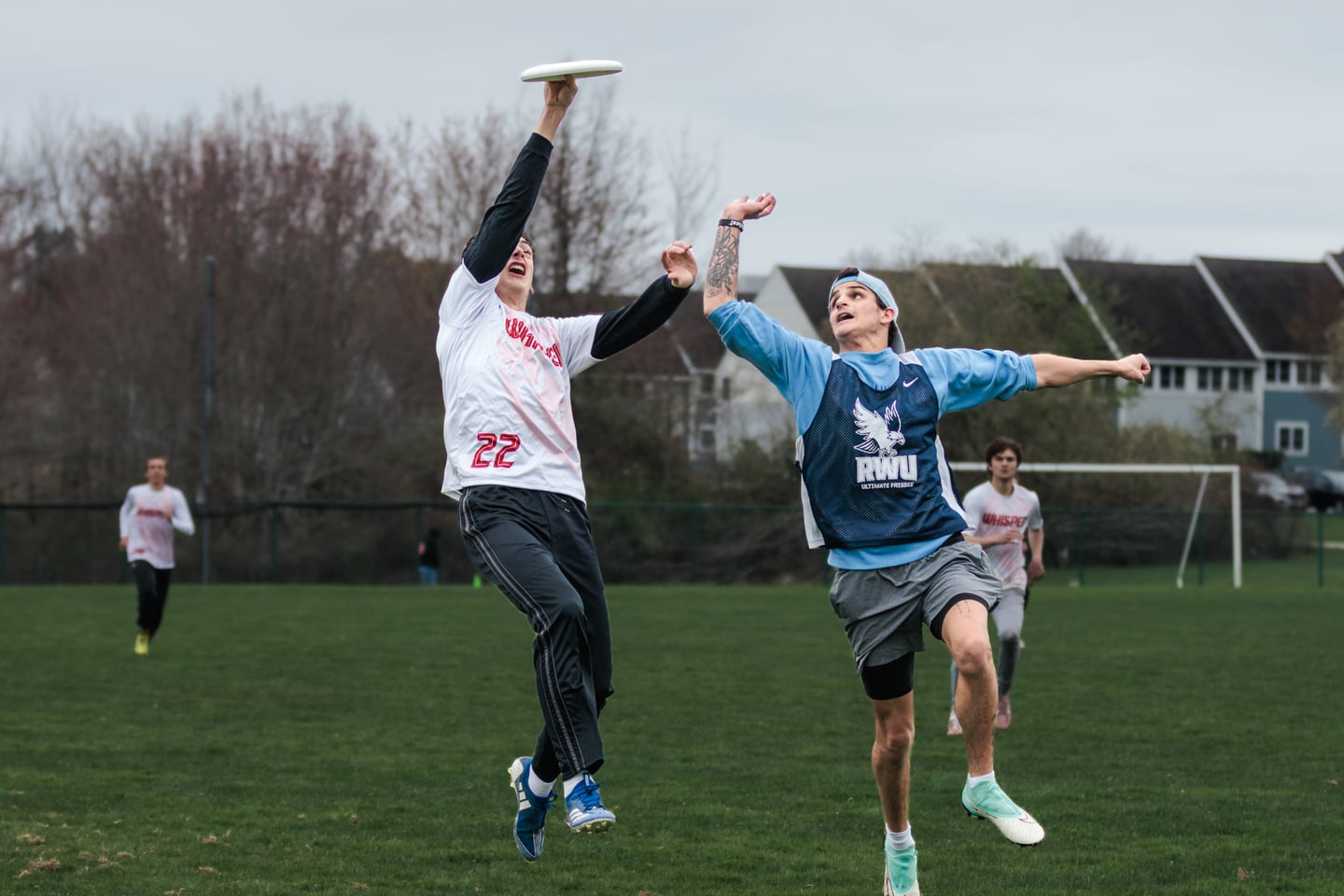 Two players rise together beneath a floating disc during a contested catch.