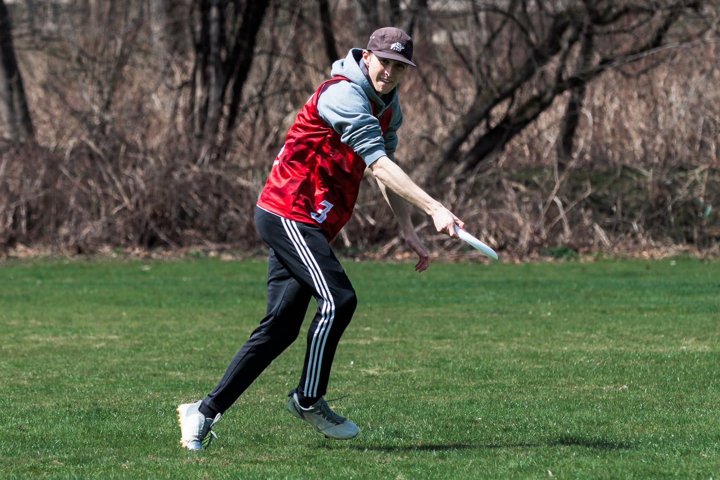 Red-clad player in a cap prepares a controlled throw.