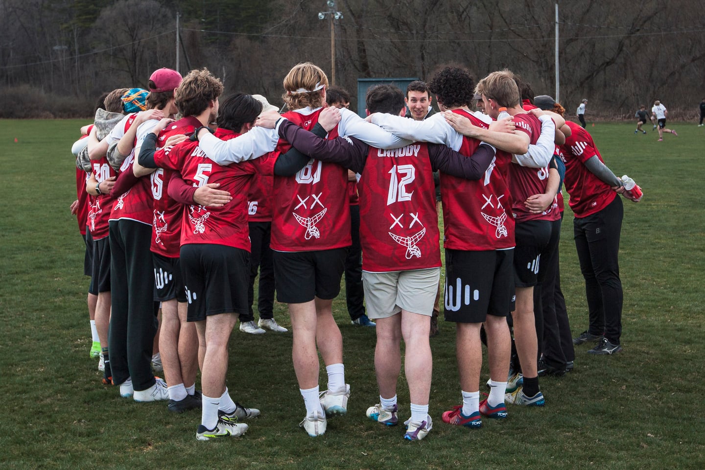 Red-clad teammates gather closely in a pre-point huddle.