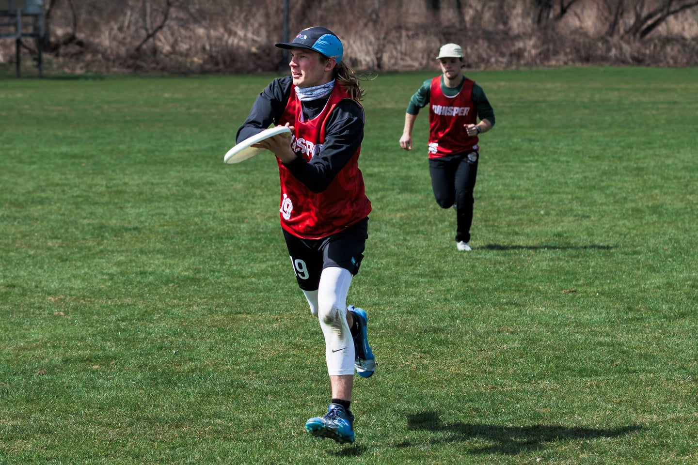 Red-clad player runs toward the camera carrying the disc.