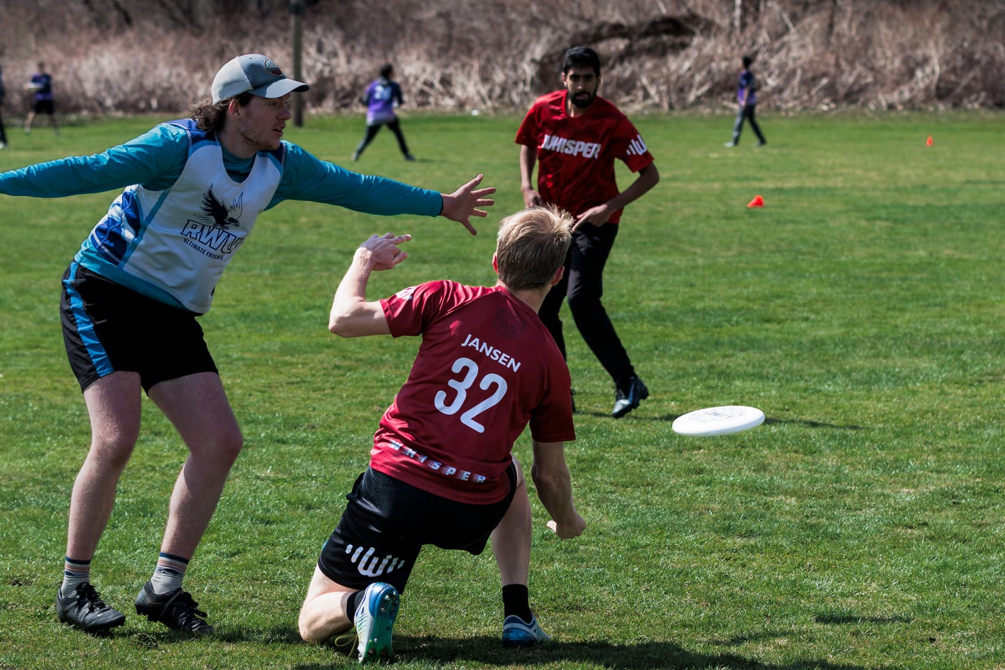 Red-clad handler pivots around an outstretched blue-clad defender.