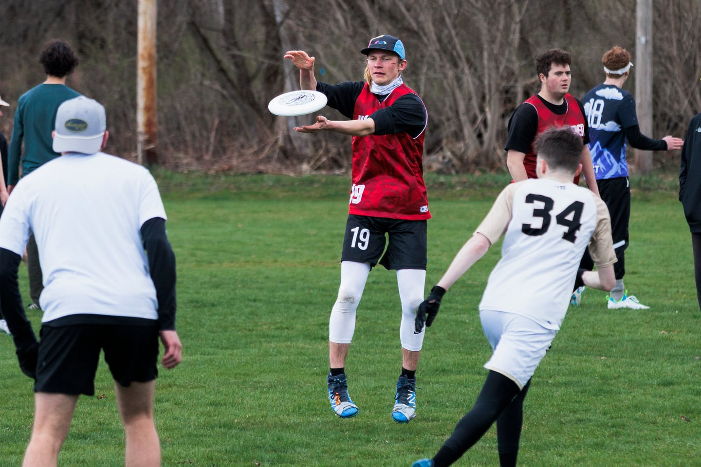 Red-clad thrower surveys the field against a white-clad marker.