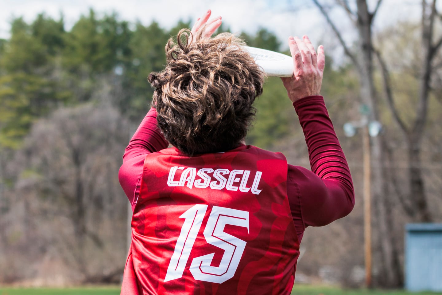 Close view of a red jersey as a player prepares to throw.