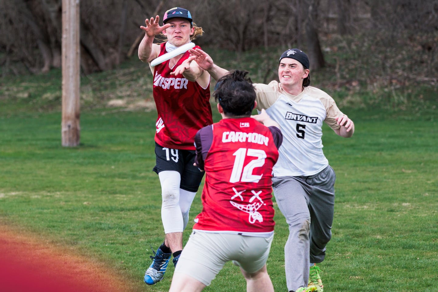 Three players contesting for the disc mid-air.