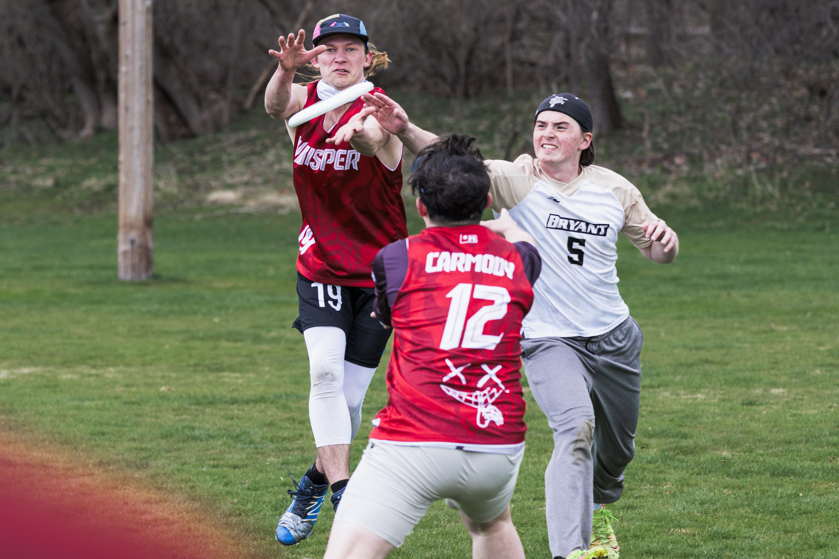 Three players contesting for the disc mid-air.