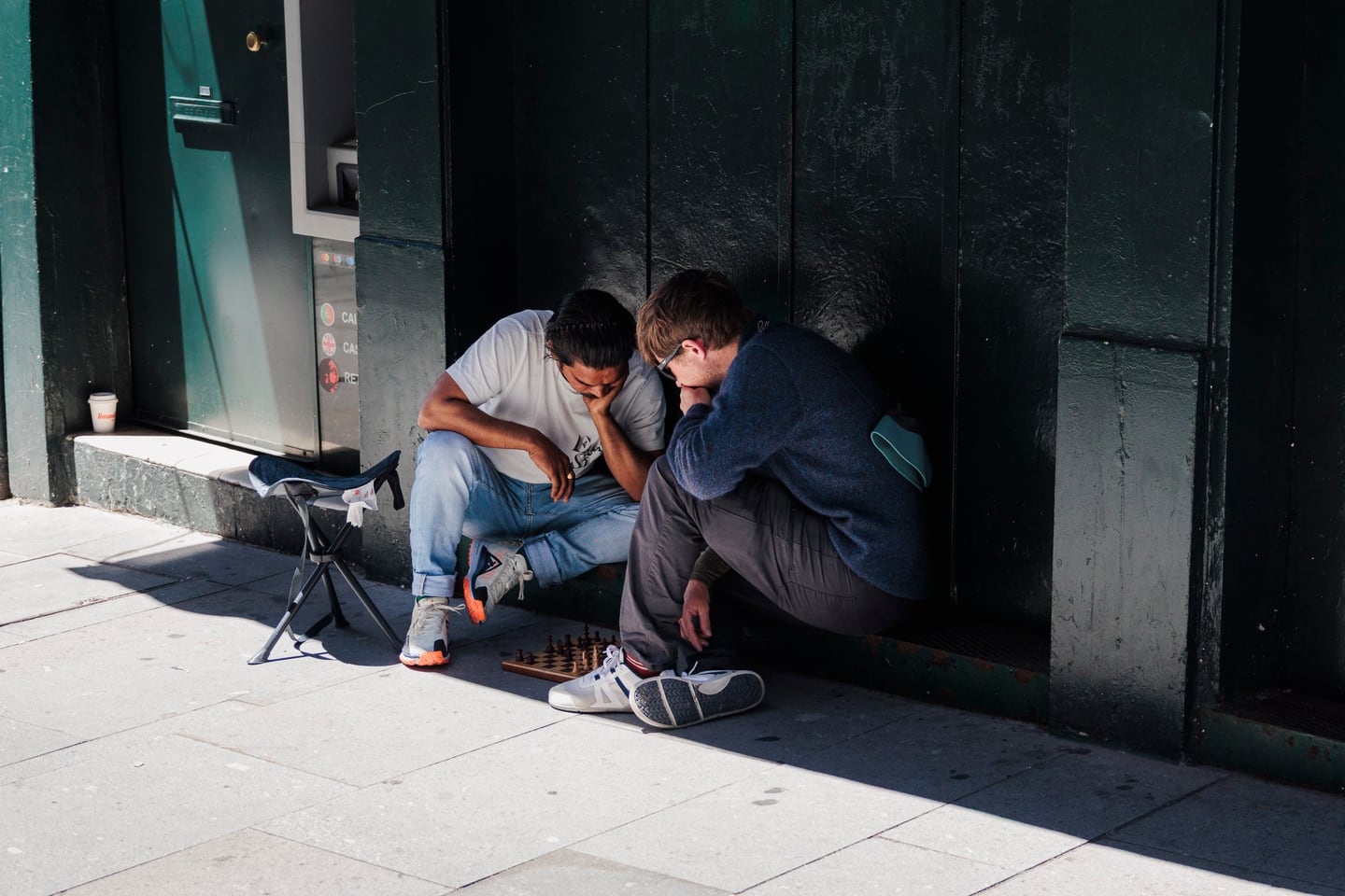 Boys standing in a shadowed doorway on a street.