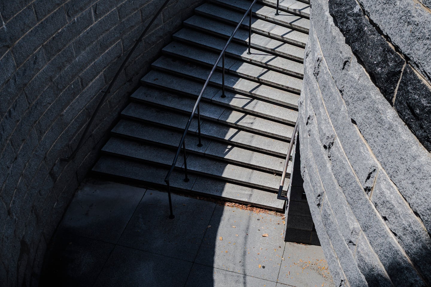 Stone stairs and layered shadows in a quiet street scene.