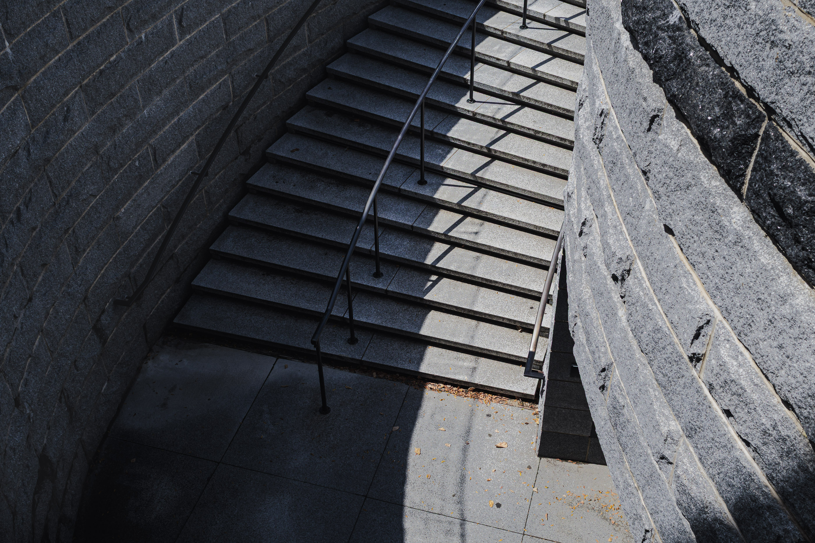 Stone stairs and layered shadows in a quiet street scene.