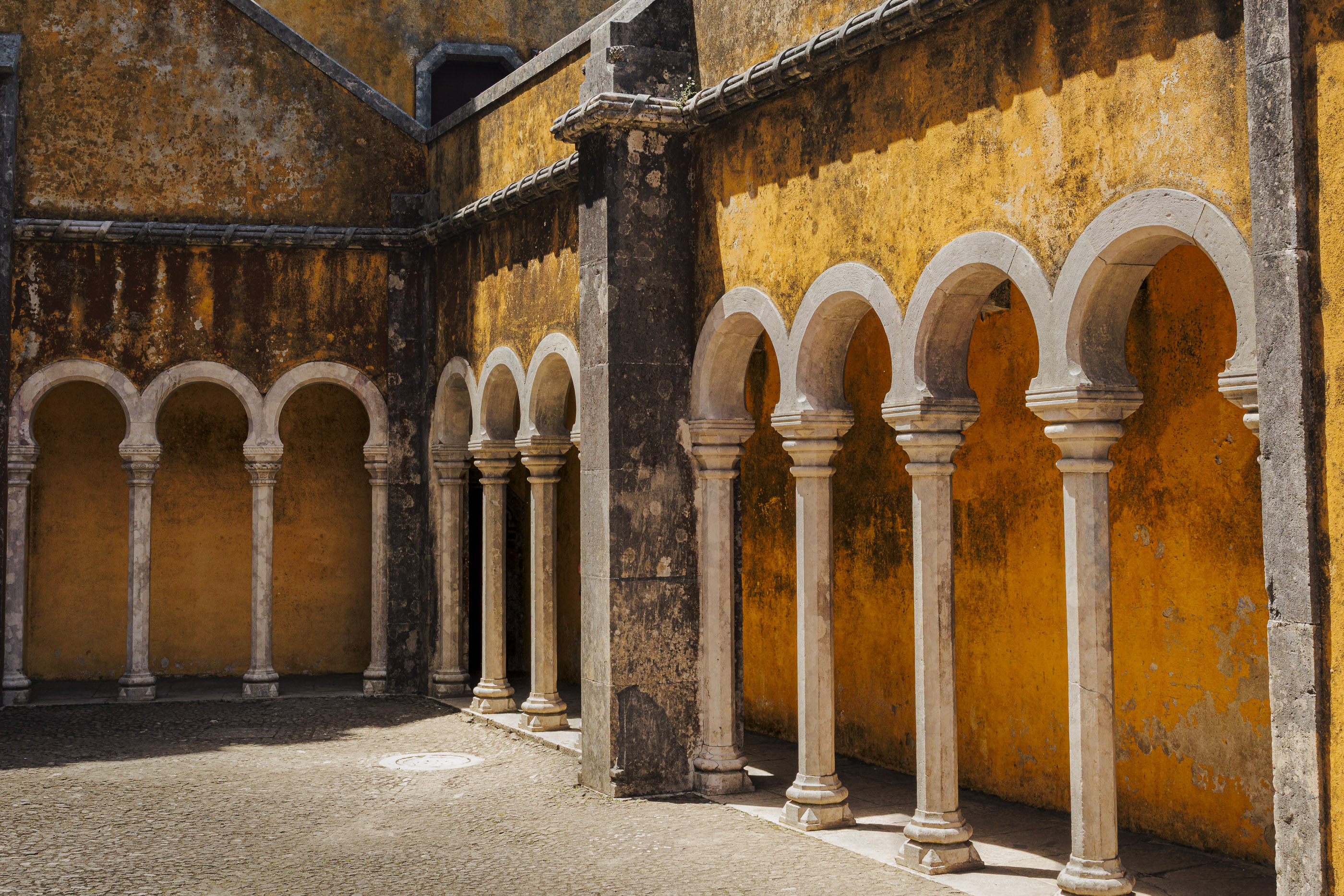 Sunlit yellow arches over a city passage.
